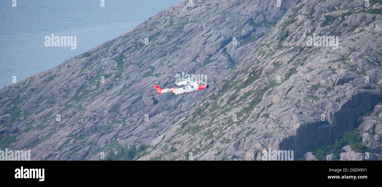 Hubschrauber, der lebensrettende Luftbrücke über felsigen Berggipfel durchführt Stockfoto