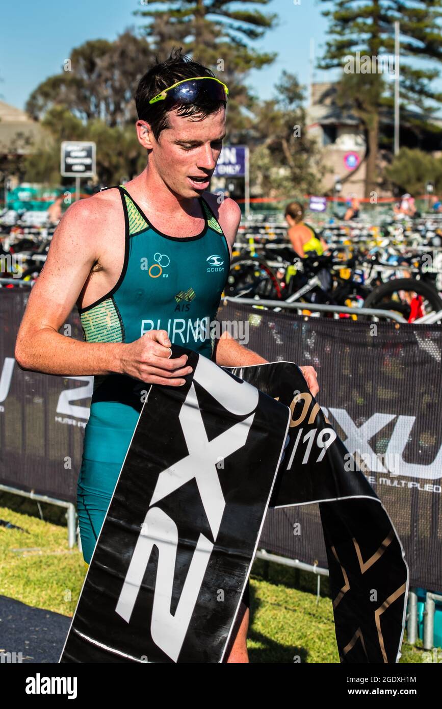 Rennsieger Luke Burns hält während der 2XU Triathlon Series 2021 am Elwood Beach ein Zielbanner. Stockfoto