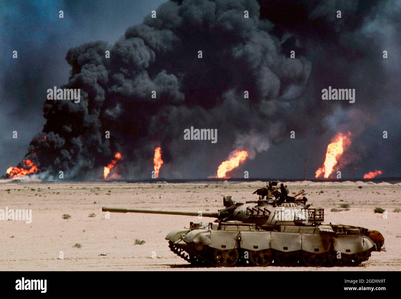 KUWAIT - Februar / März 1991 - ein verlassene russische T-62-Panzer in der Wüste vor brennenden Ölquellen wurden Bilder wie diese zur Ikone Stockfoto