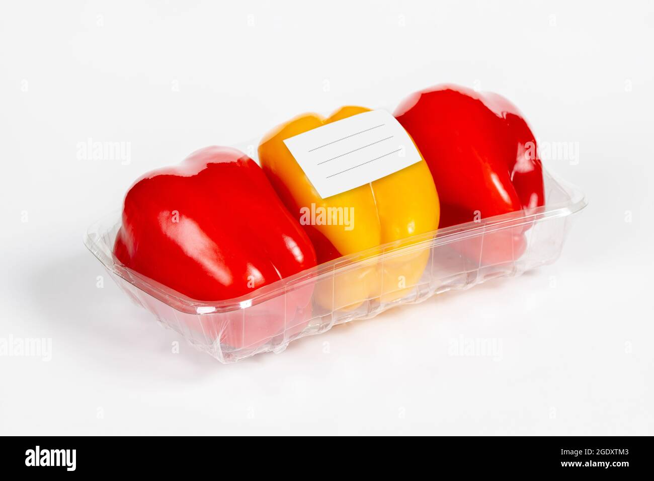 Packung mit rotem und gelbem Pfeffer mit weißem Etikett auf isoliertem weißem Hintergrund Stockfoto