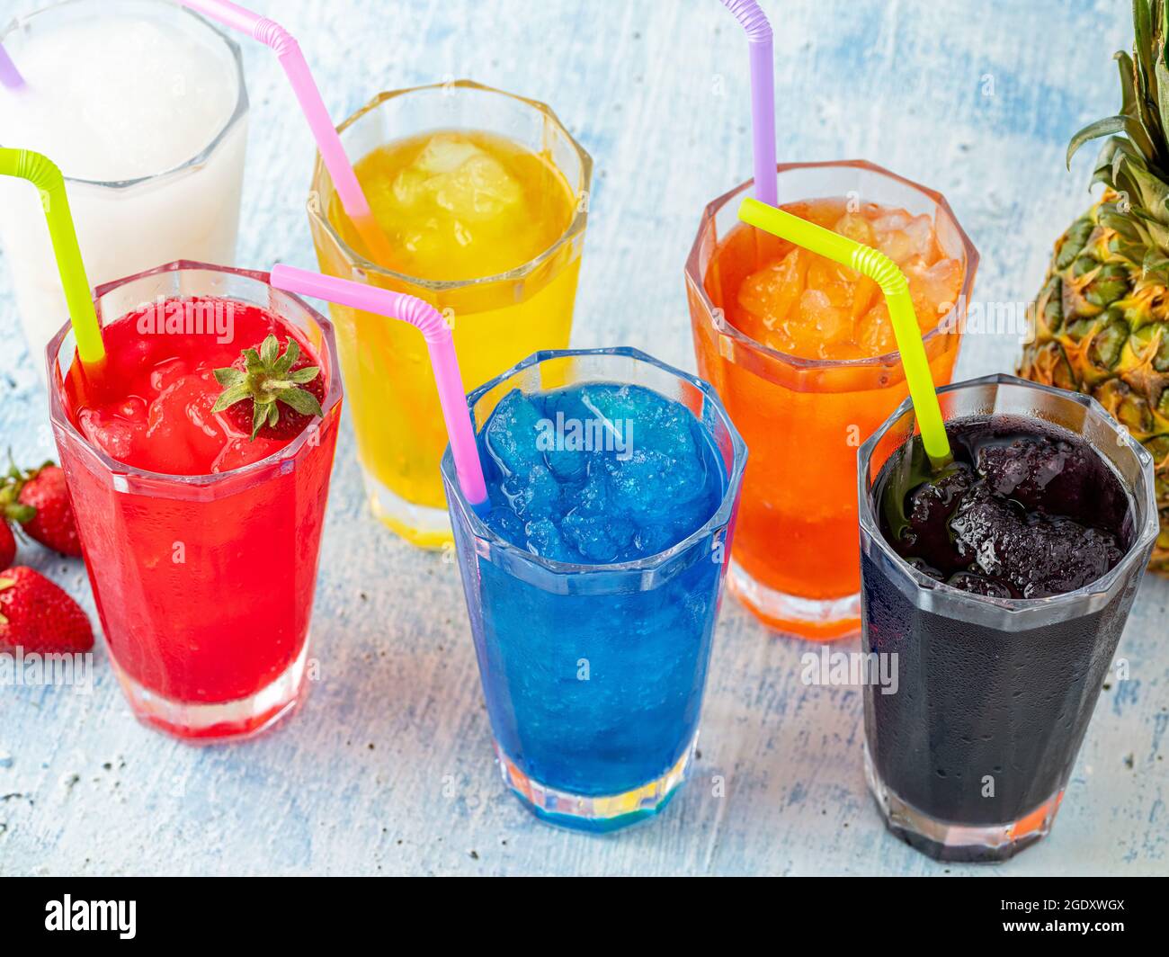 Erfrischende Frozen in verschiedenen Früchten und Farben auf blauem Hintergrund. Stockfoto