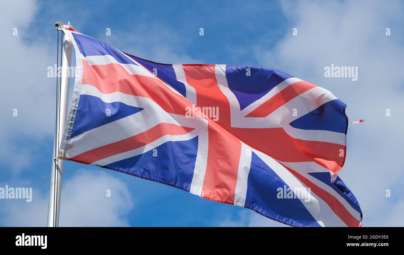 Eine Union Jack Flag, die von einem Fahnenmast am Himmel, der Nationalflagge des Vereinigten Königreichs von Großbritannien, fliegt Stockfoto