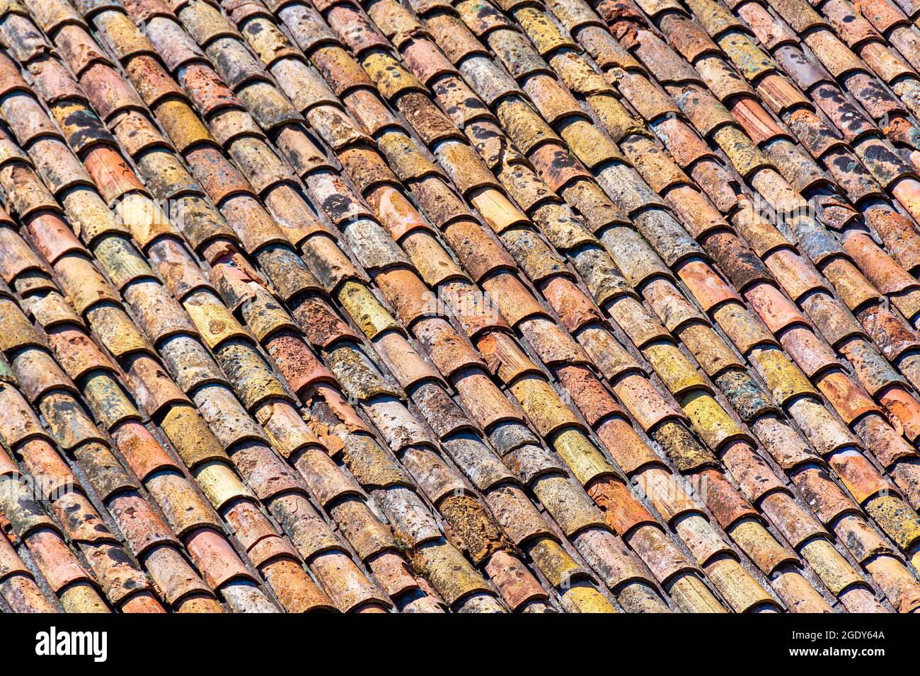 Altes Dach aus traditionellen römischen Terrakotta-Fliesen auf einem alten Haus im Süden Frankreichs. Nahaufnahme für Textur Stockfoto