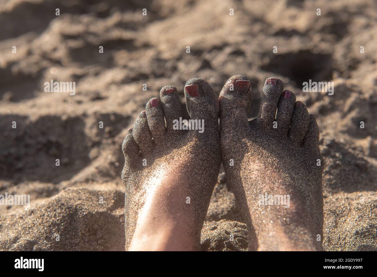 Weibliche Füße am Strand Stockfoto