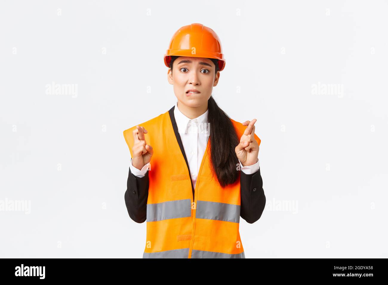 Besorgt hoffnungsvoll asiatische Architektin Gefühl nervös, wie auf Inspektionsergebnisse in der Baustelle warten, tragen Schutzhelm, Kreuzfinger Stockfoto