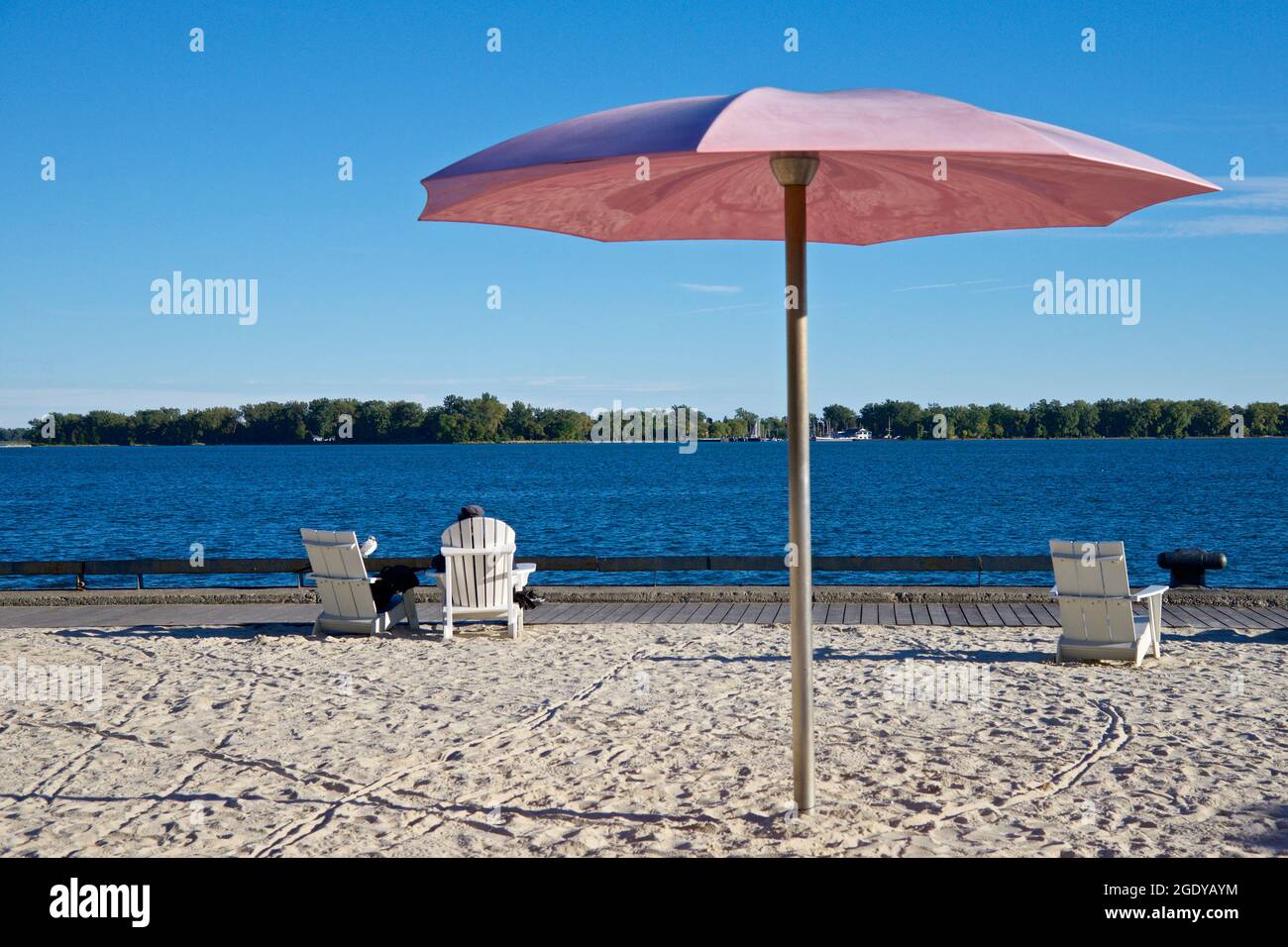 Menschen, die sich am Strand mit einem Sonnenschirm sonnen Stockfoto