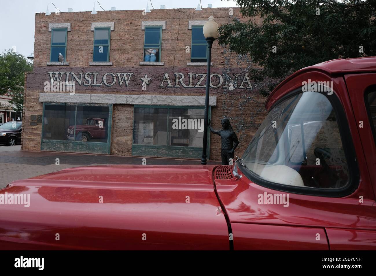 Winslow, Arizona, USA. August 2021. Standin' on the Corner Park in Winslow, Arizona. Eine Statue des Eagles-Mitglieds Glen Frey erinnert an den Hit Take IT Easy aus den 1960er Jahren mit der Zeile „nun, ich stehe an der Ecke in Winslow, Arizona, und es gibt einen so schönen Anblick zu sehen. Es ist ein Mädchen, mein Herr, in einer flachen Furt, die langsam einen Schau mich an. nimmt. Der Park enthält ein zweistöckiges Trompe-l'Ceil-Wandgemälde von John Hugh sowie eine Statue eines Mannes, der eine Gitarre vom Bildhauer Ron Adamson hält. Winslow ist ein beliebtes Touristenziel auf der berühmten alten Route 66, die sich im Navajo Reservat befindet. (C Stockfoto