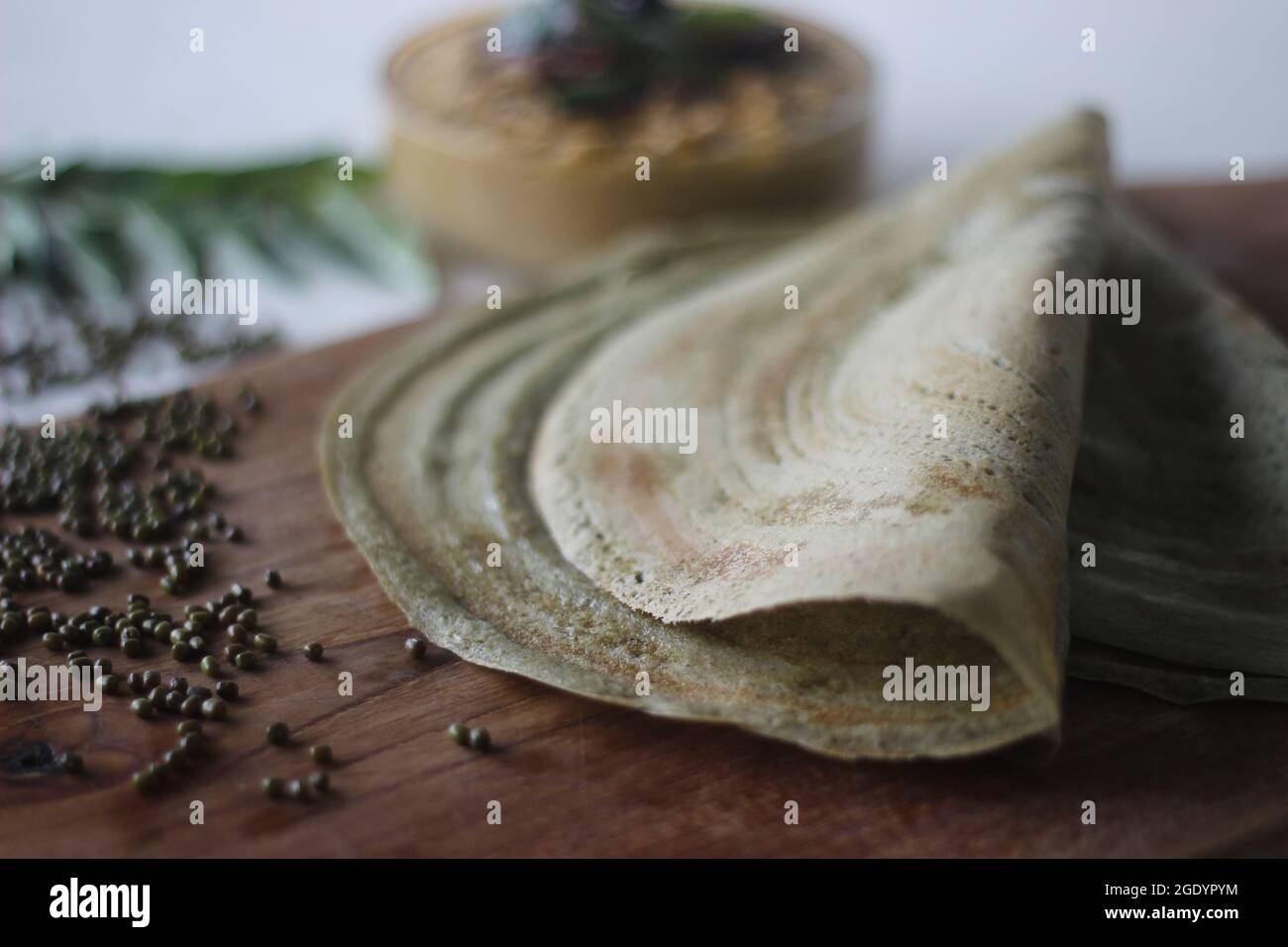 Eiweißreicher Moong-Bohne-Crepe, lokal als Pesarattu bekannt. Es sieht aus wie Dosa, aber nicht mit fermentiertem Teig. Serviert zusammen mit Kokosnuss chu gefaltet Stockfoto