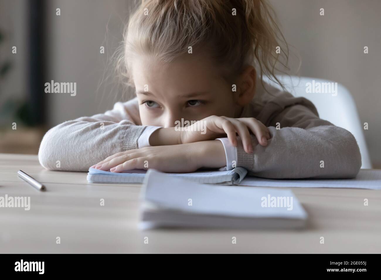 Unglückliches kleines Mädchen fühlt sich faul beim Studieren zu Hause Stockfoto