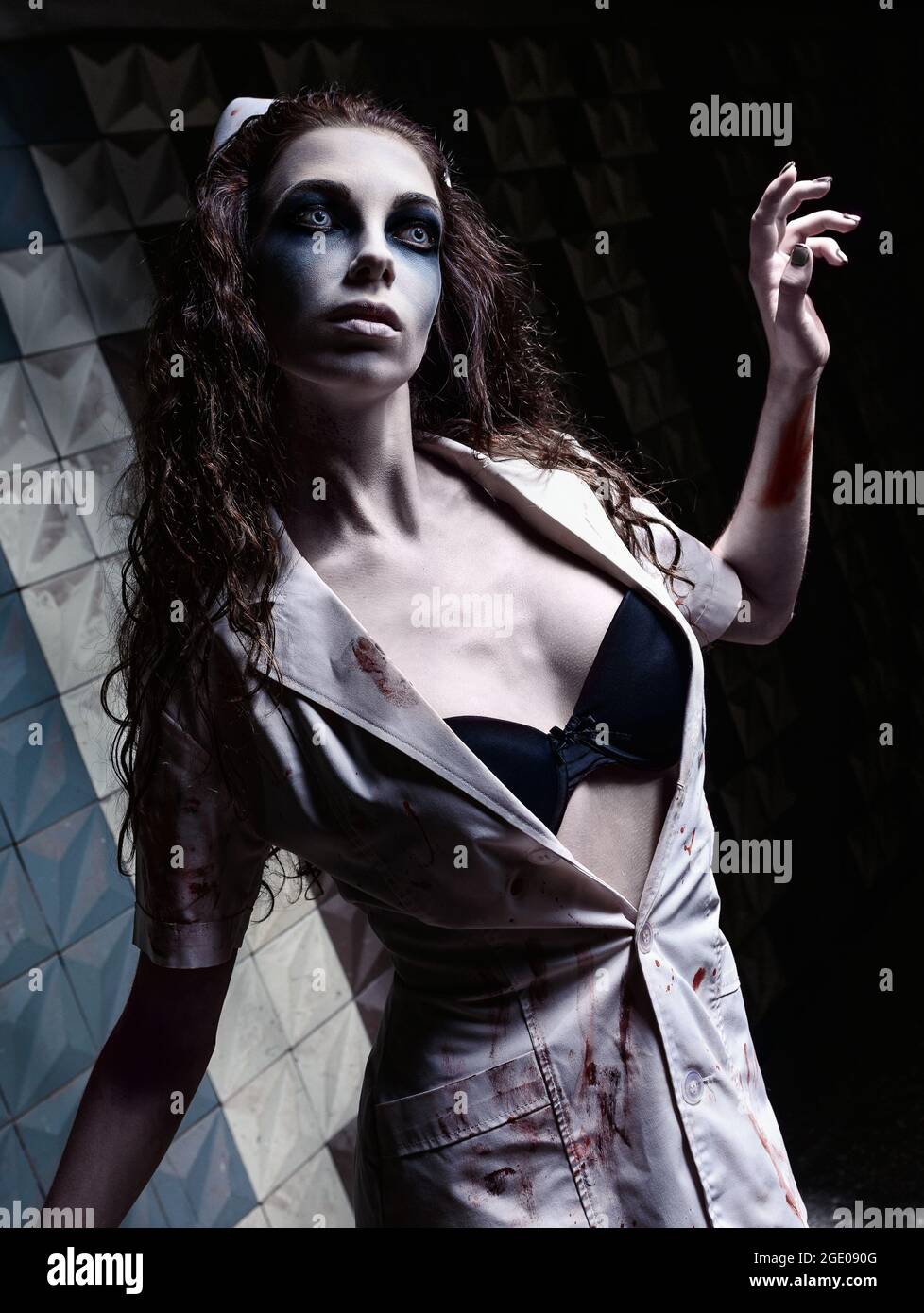 Horrorfoto: Die komische, düstere Krankenschwester (Arzt) in blutiger Uniform. Zombie-Mädchen (lebend tot) Stockfoto