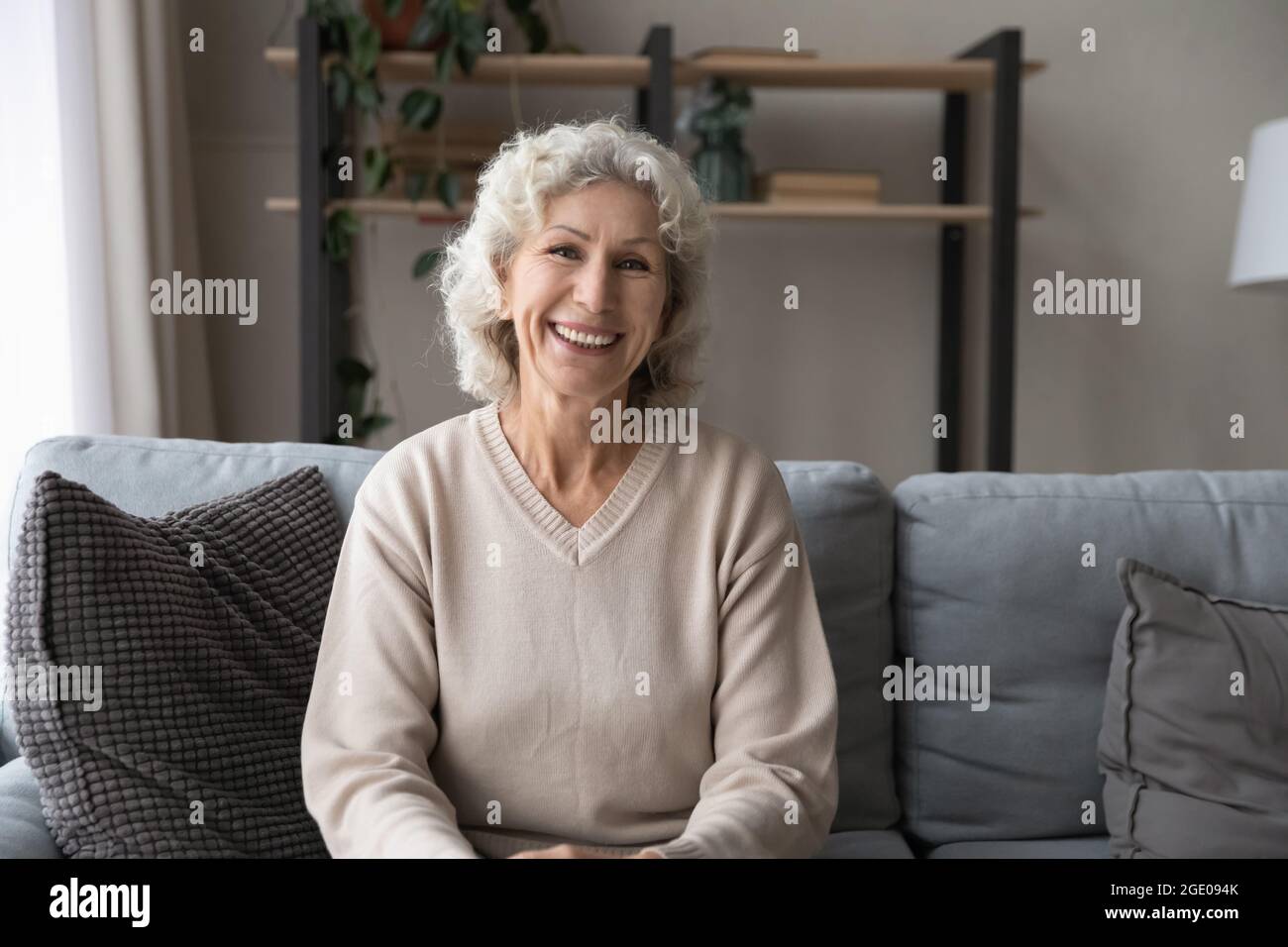Porträt einer glücklichen älteren Frau ruhen auf dem Sofa Stockfoto