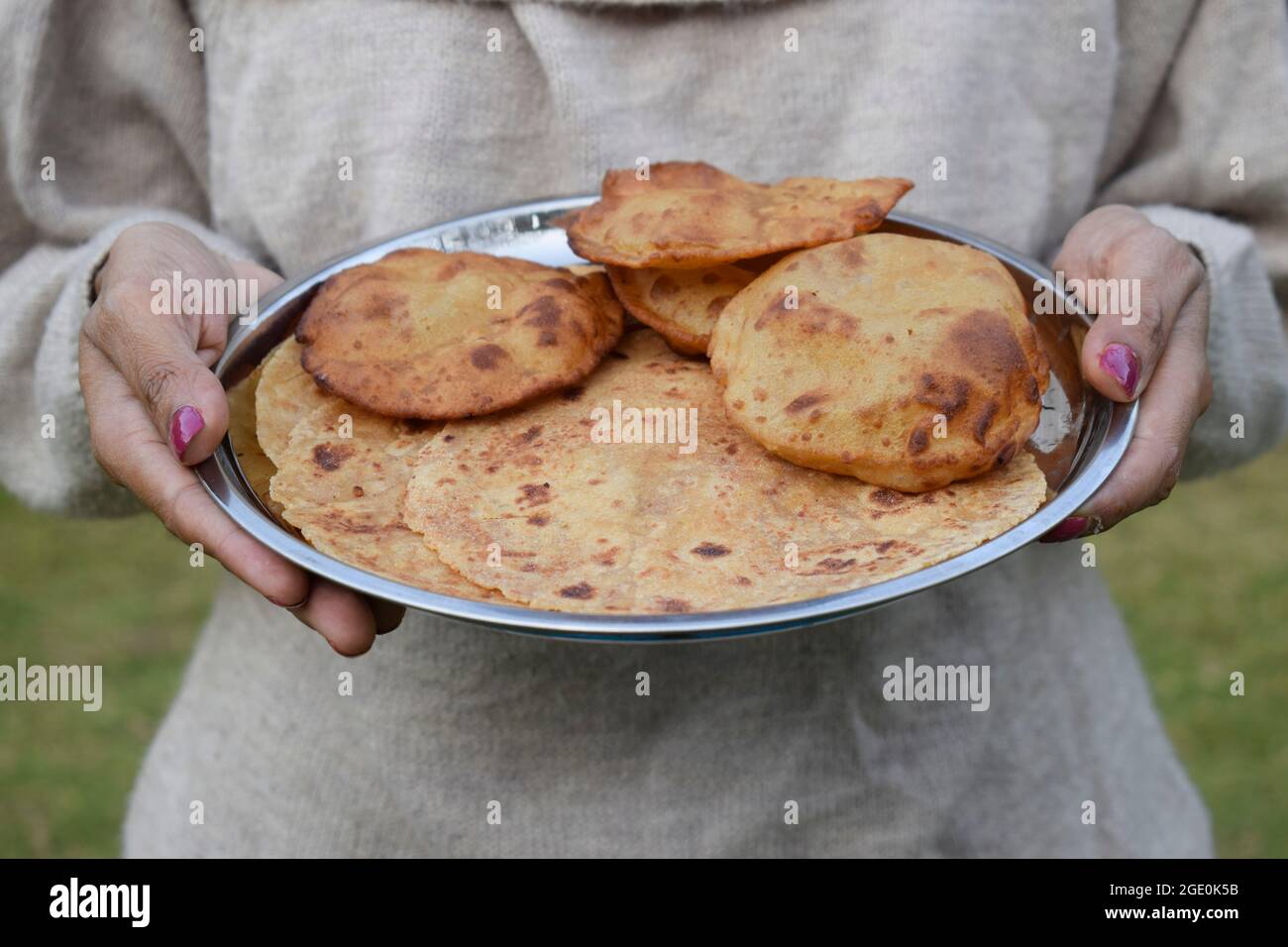 Weibchen hält Thaali des indischen Fastfood-Artikels Rajgira paratha und puri zum Mittag- oder Abendessen während Fastentage wie navratri, Mahashivratri, Ekada Stockfoto