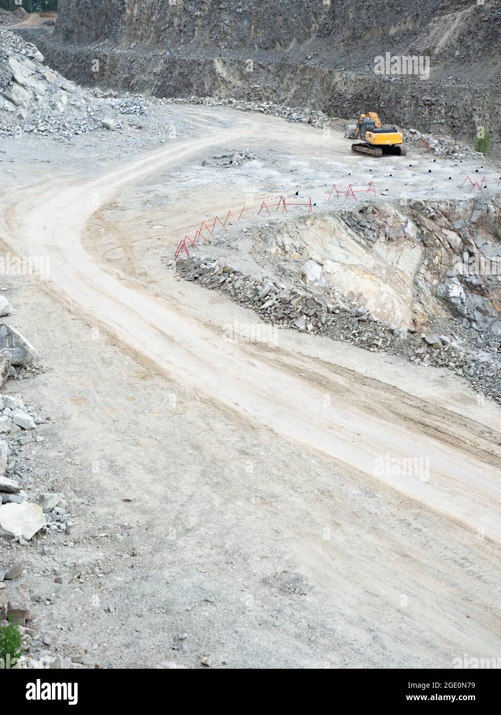 Bagger arbeiten an Erdarbeiten im Tagebau. Bagger gräbt Granitkies im Steinbruch Stockfoto