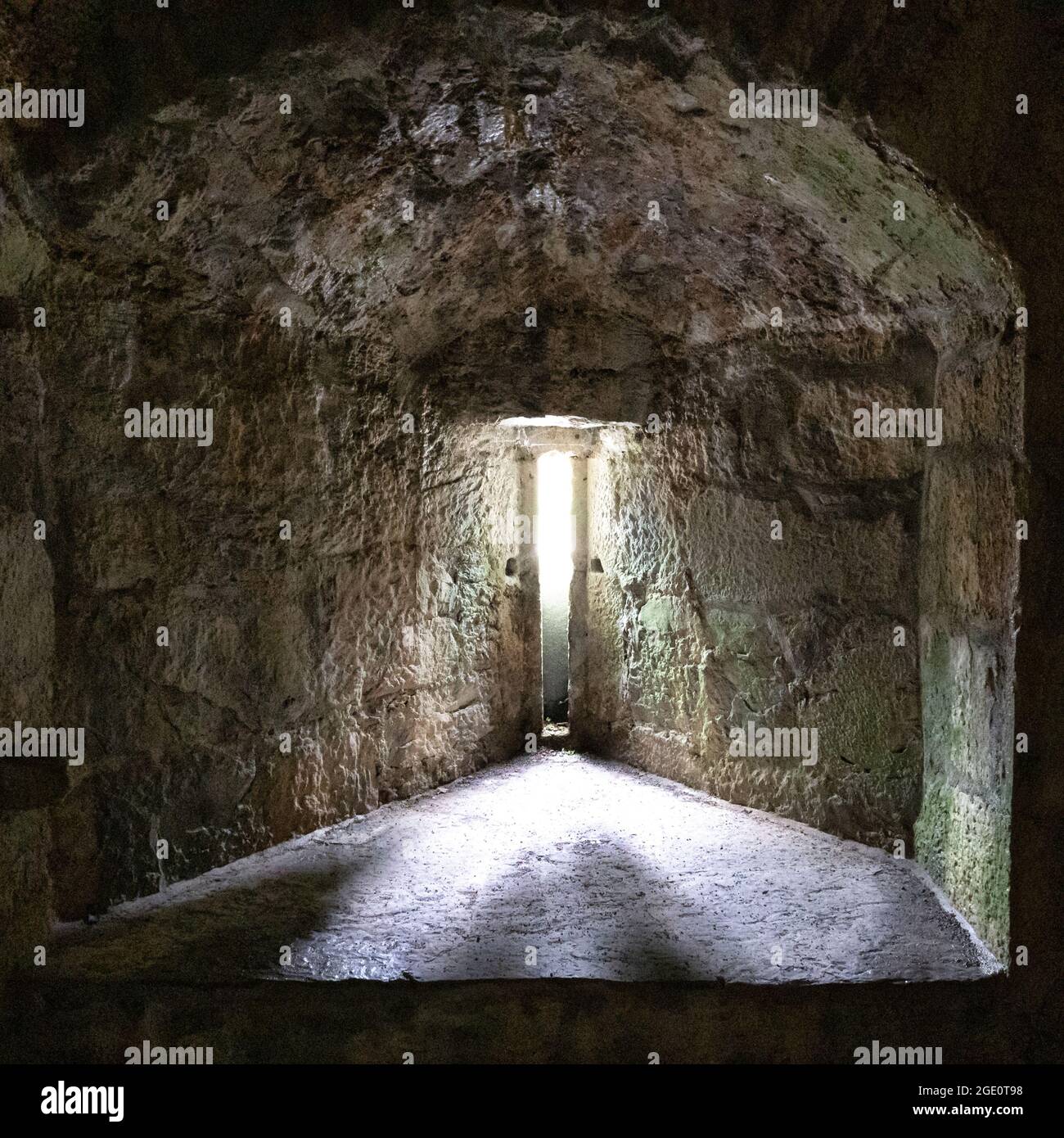 Licht, das durch einen dünnen Schlitz eines Burgfensters scheint Stockfoto
