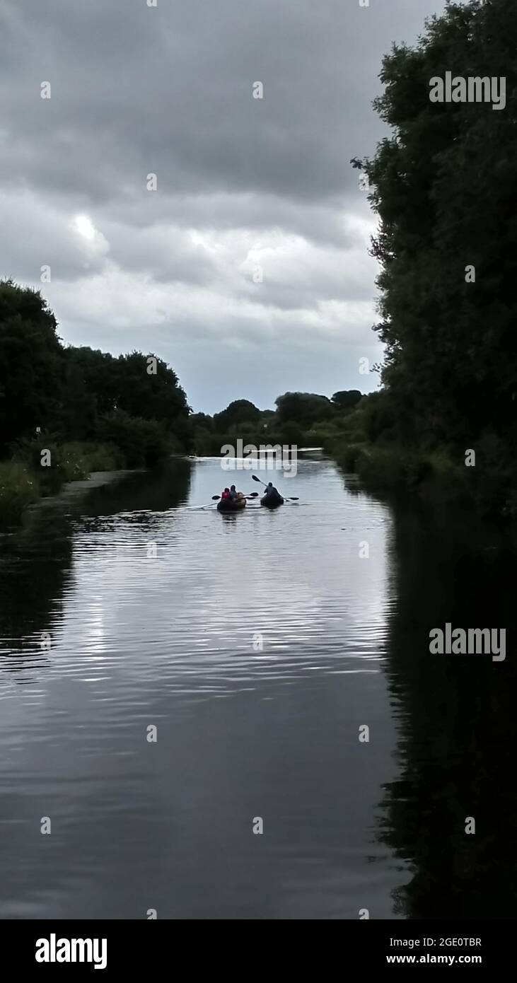 Vier nicht identifizierbare Personen, die Kajaks in einem Kanal in Exeter, Devon, England, Großbritannien, benutzen. Stockfoto