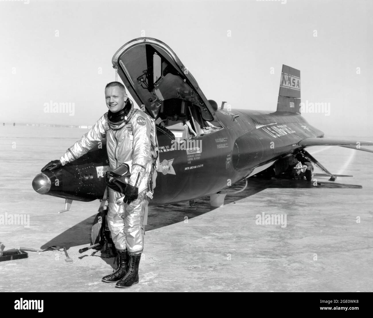 Dryden-Pilot Neil Armstrong ist hier neben dem X-15-Schiff #1 (56-6670) nach einem Forschungsflug zu sehen. Die X-15 war ein Raketenflugzeug, das 50 Fuß lang war und eine Flügelspannweite von 22 Fuß hatte. Es war ein raketenförmiges Fahrzeug mit einem ungewöhnlichen keilförmigen vertikalen Schwanz, dünnen, steigenartigen Flügeln und einzigartigen Seitenverkleidungen, die sich entlang der Seite des Rumpfes ausdehnten. Die X-15 wurde über einen Zeitraum von fast 10 Jahren geflogen, von Juni 1959 bis Oktober 1968. Sie stellte die inoffiziellen Geschwindigkeits- und Höhenrekorde der Welt auf. Die aus dem äußerst erfolgreichen X-15-Programm gewonnenen Informationen trugen zur Entwicklung des Mercury bei. Stockfoto