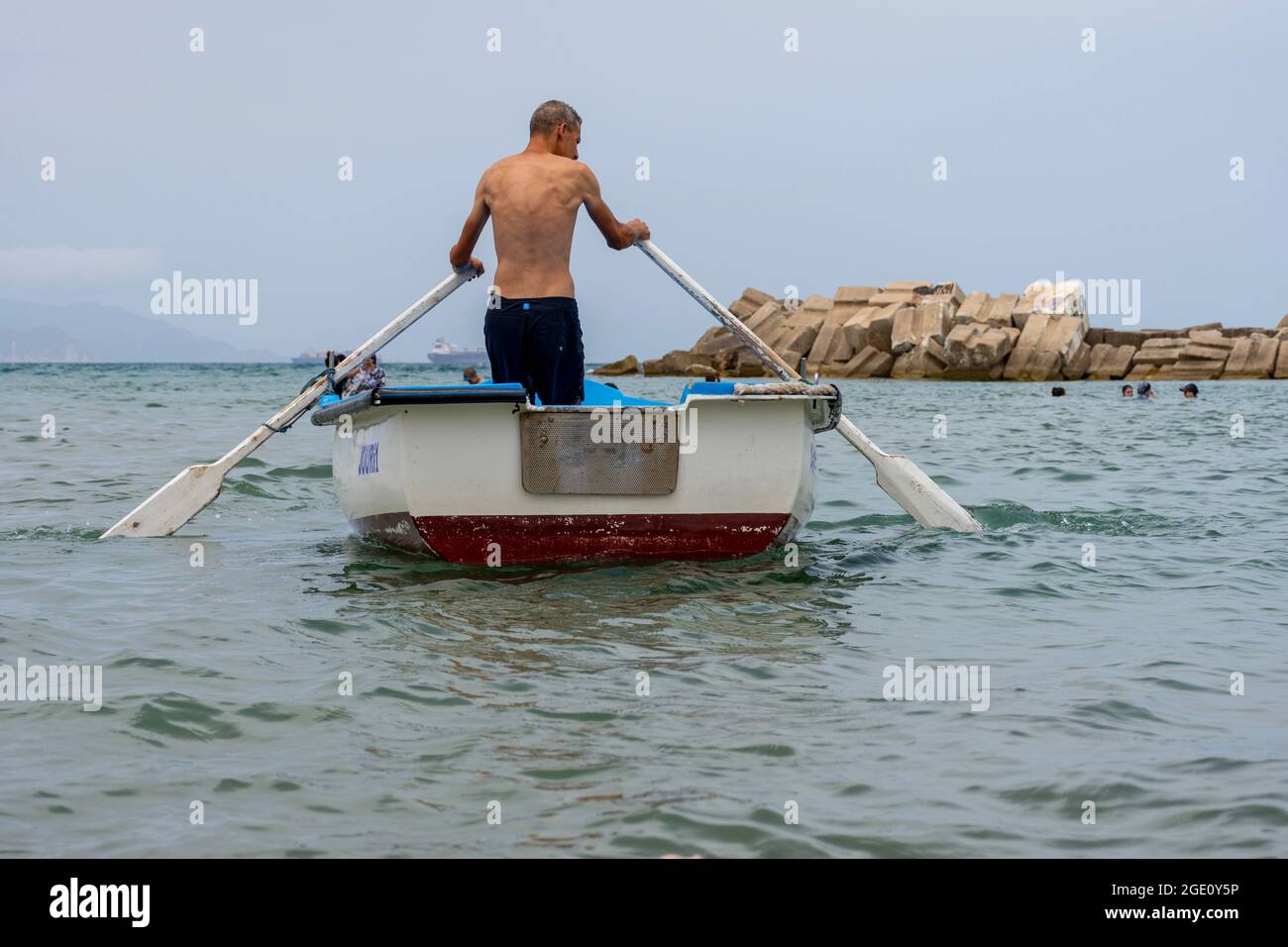 Low-Angle-Ansicht eines Mannes, der auf einem Boot in Skikda, Algerien rudert. Stockfoto