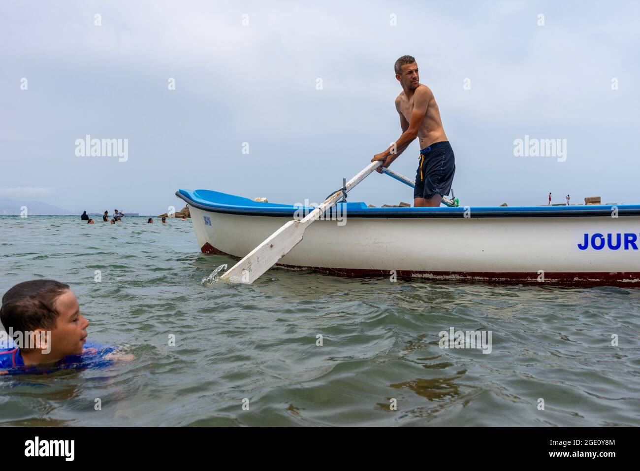 Low-Angle-Ansicht eines Mannes, der auf einem Boot in Skikda, Algerien rudert. Stockfoto