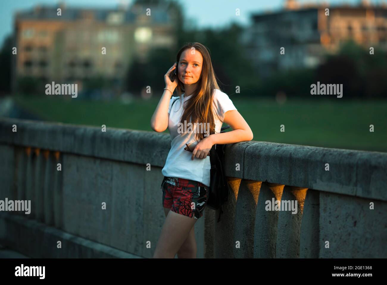 Ein Mädchen im Teenageralter telefoniert am Stadtdamm. Stockfoto