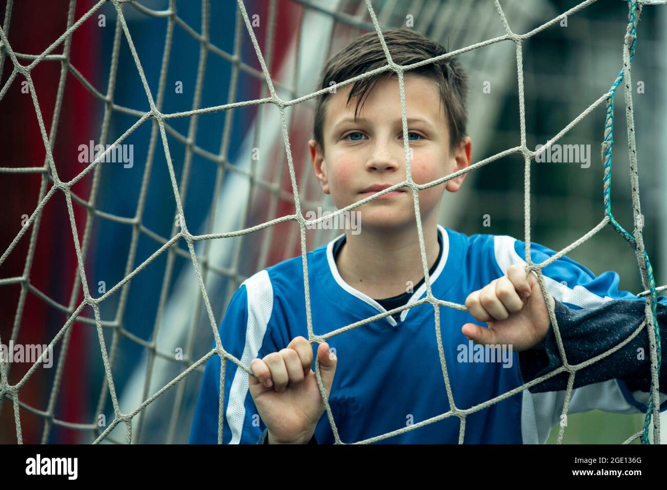 Ein Nahaufnahme-Porträt eines Jungen im Teenageralter in der Nähe des Tores auf dem Fußballfeld. Stockfoto