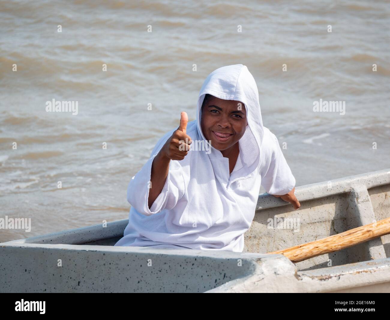 Ryohacha, La Guajira, Kolumbien - 30 2021. Mai: Junger schwarzer Latein in weißem Smiles an der Kamera, während er auf einem Boot sitzt Stockfoto