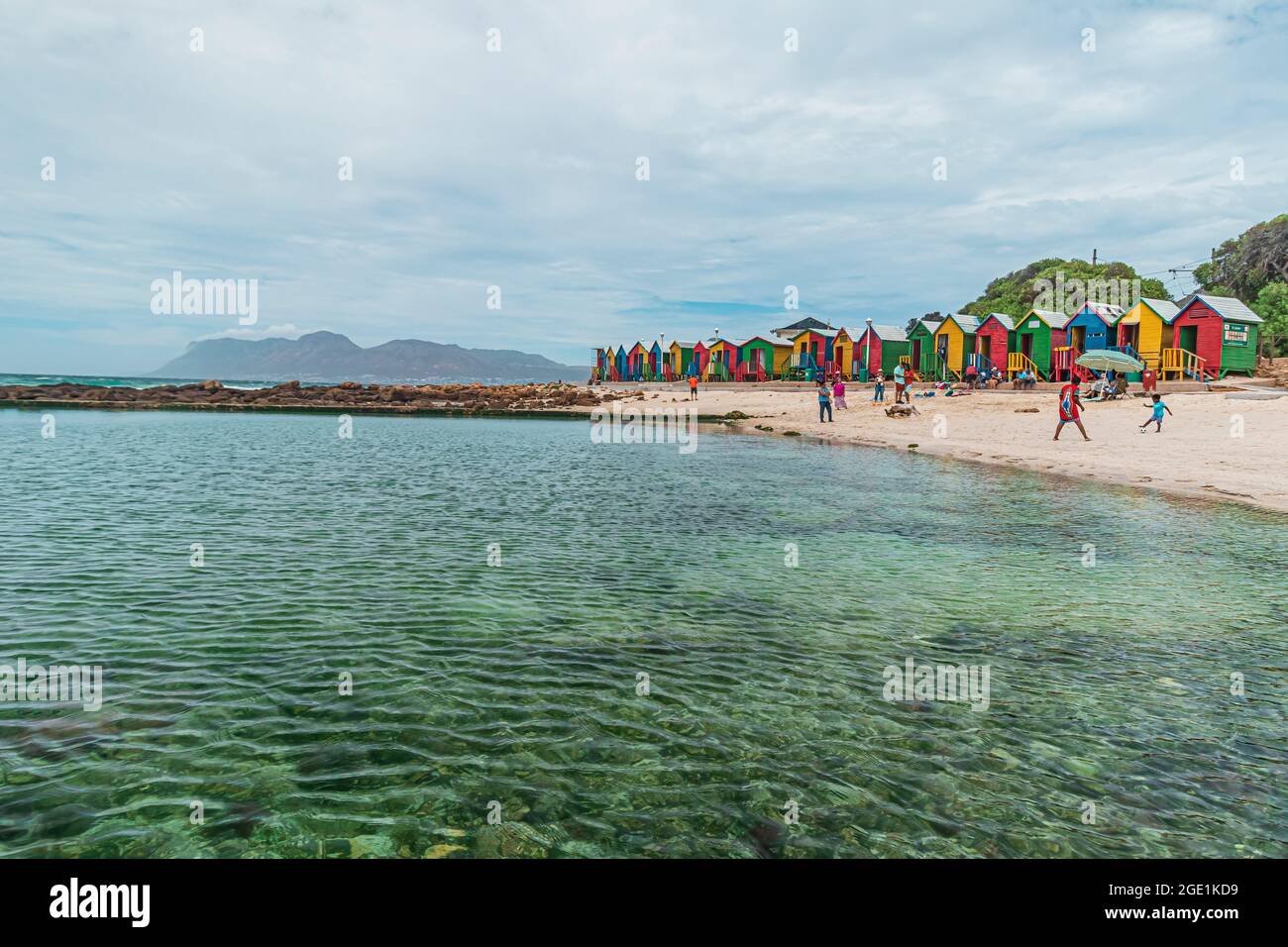 Meer und Strand von Muizenberg Strand mit seinen berühmten bunten Strandhütten in Muizenberg, der Küstenstadt an der False Bay der Kap-Halbinsel, Südafrika. Stockfoto