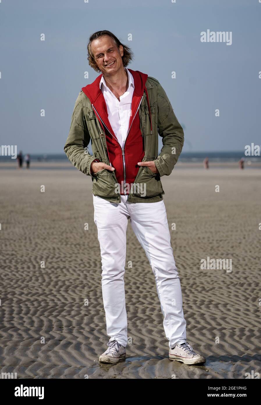 sankt peter ording deutschland august 2021 ralf bauer steht in der sonne am strand von st peter ording bauer prasentiert seinen ersten film uber das surfen und den tibet konflikt quelle axel heimken dpa alamy