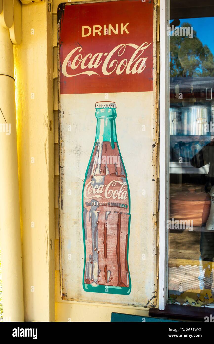 Ein Schild mit der Werbung für ein Coca Cola-Geschäft mit altem Getränk. Stockfoto
