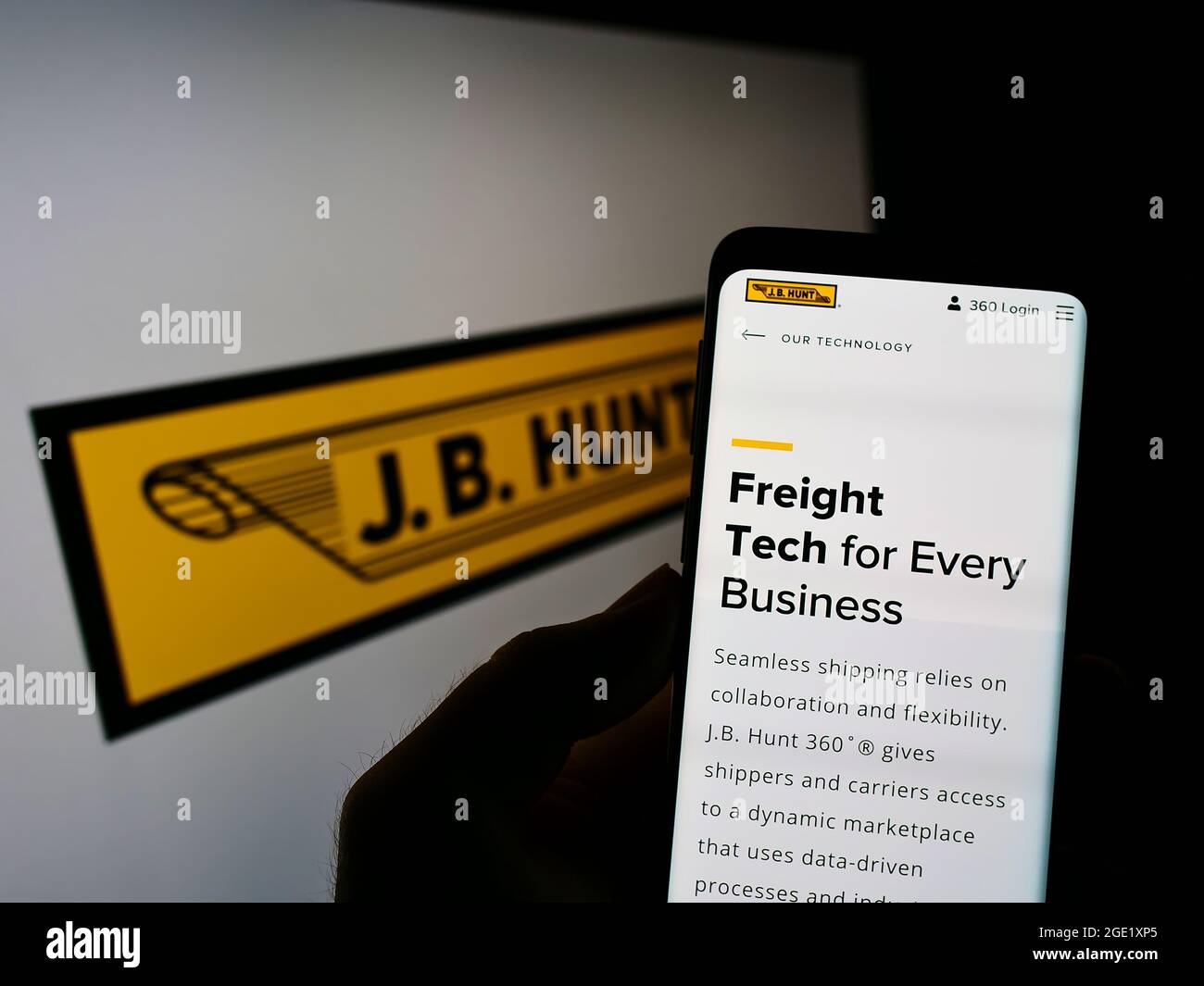 Person, die Mobiltelefon mit der Webseite des Logistikunternehmens J.B. hält Hunt Transport Services Inc. Auf dem Bildschirm mit Logo. Konzentrieren Sie sich auf die Mitte des Telefondisplays. Stockfoto