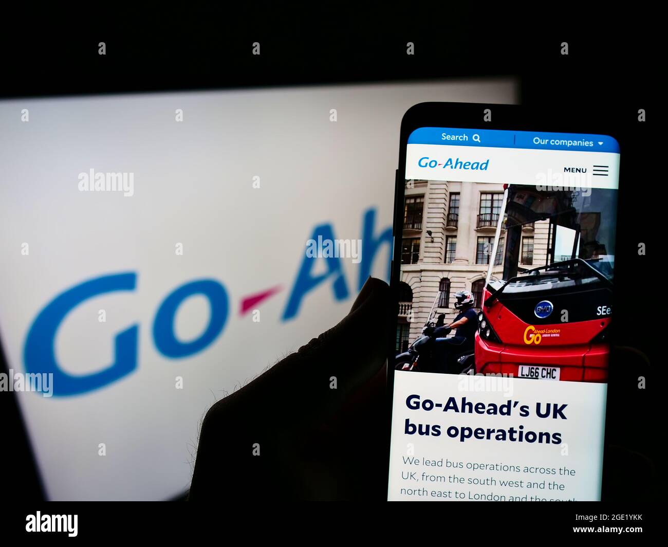 Person mit Mobiltelefon und Webseite des britischen Transportunternehmens The Go-Ahead Group plc auf dem Bildschirm mit Logo. Konzentrieren Sie sich auf die Mitte des Telefondisplays. Stockfoto