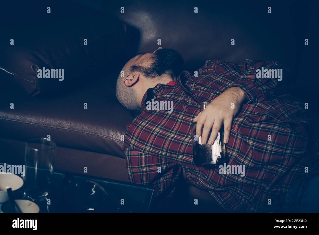 Betrunkener Mann auf dem Sofa. Alkoholismus, Alkoholabhängigkeit, Drogenabhängigkeit Stockfoto