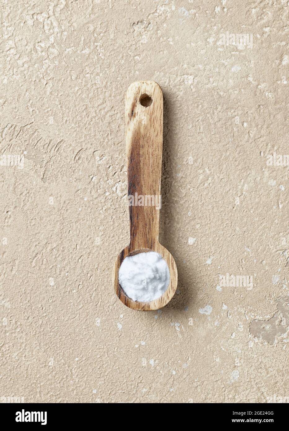 Backpulver in Holzlöffel auf beigefarbenem Tischhintergrund, Draufsicht Stockfoto