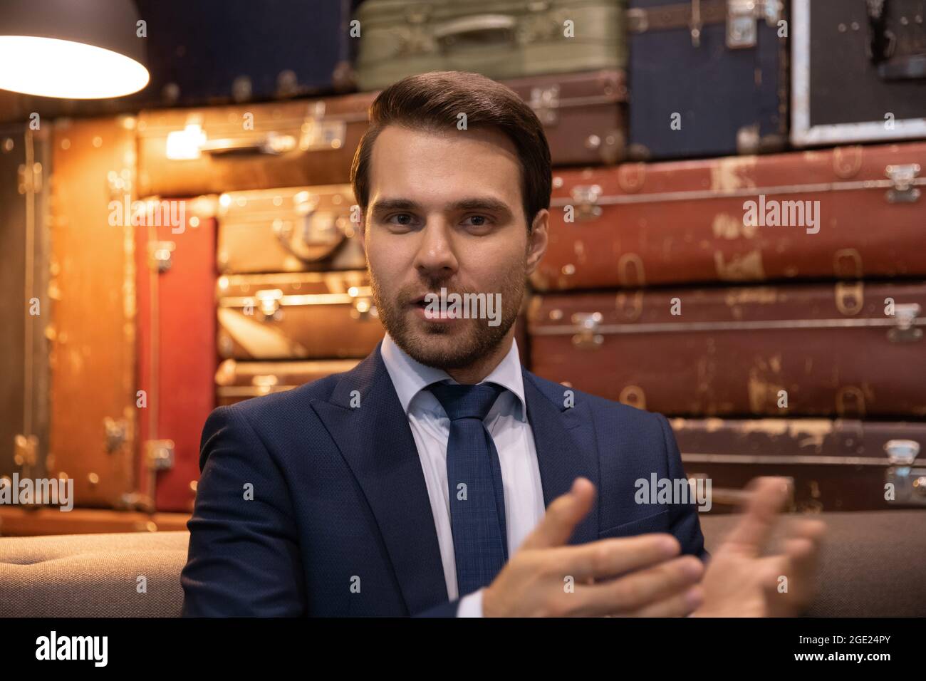 Ein Geschäftsmann im Anzug leitet die formelle Kommunikation und verhandelt per Videokonferenz aus der Ferne Stockfoto