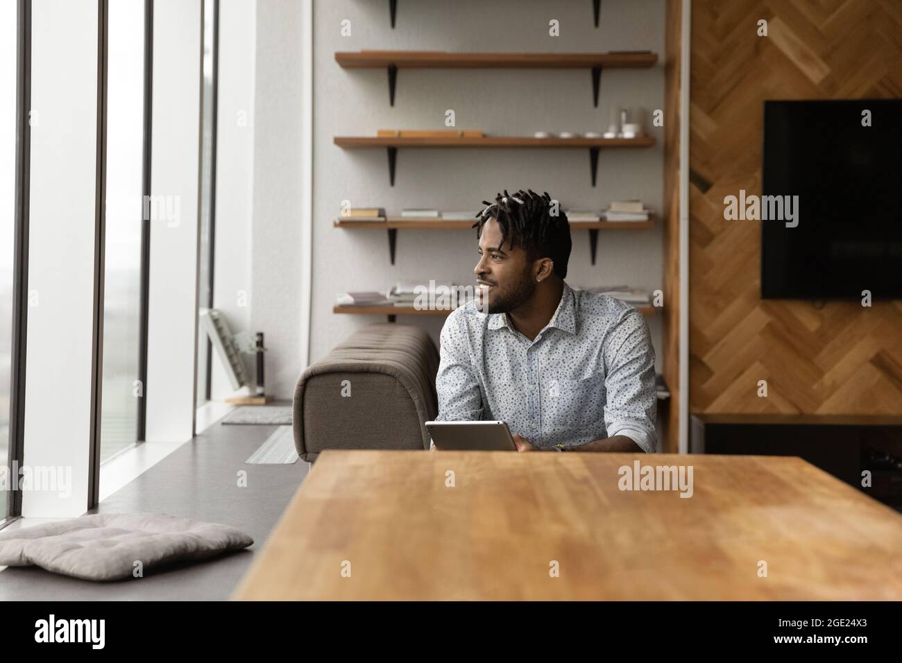 Afrikanischer Kerl halten Tablette beiseite schauen, Tagträume über Karrierewachstum Stockfoto