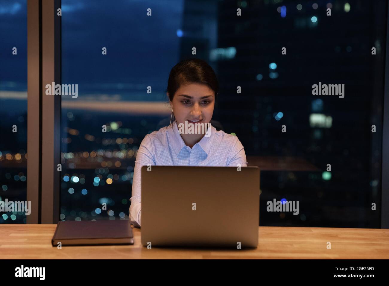 Indische Geschäftsfrau sitzt am Arbeitsplatz und arbeitet bis spät in die Nacht am Laptop Stockfoto