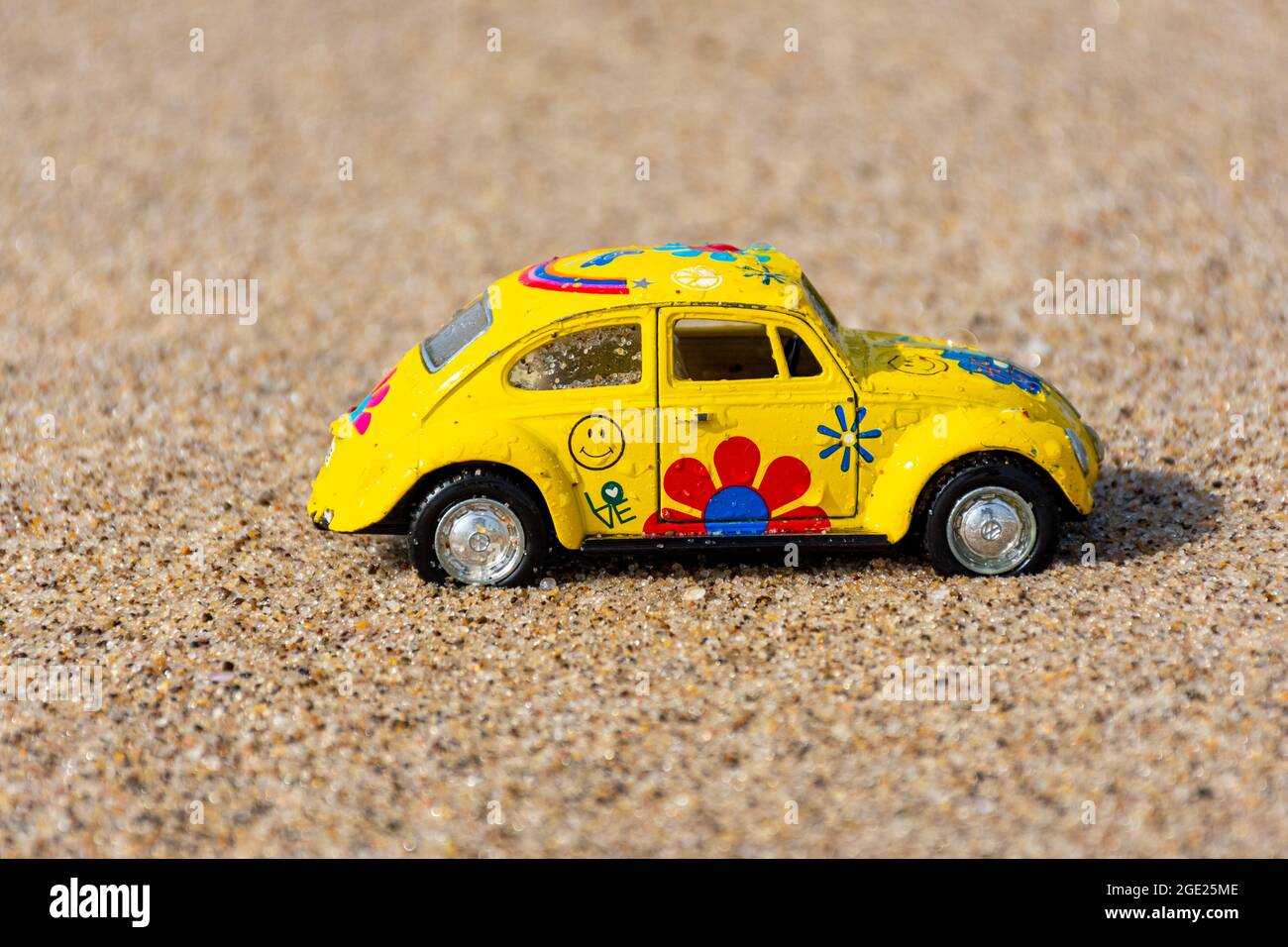 Gelber Volkswagen Käfer aus Metall am Strand. Stockfoto