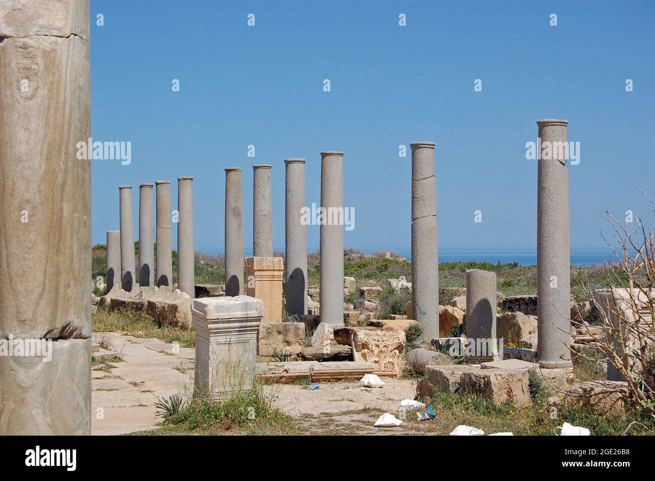 Alte römische Steinsäulen in der Nähe der Küste in der zerstörten Stadt Leptis Magna an der Küste Libyens. Stockfoto