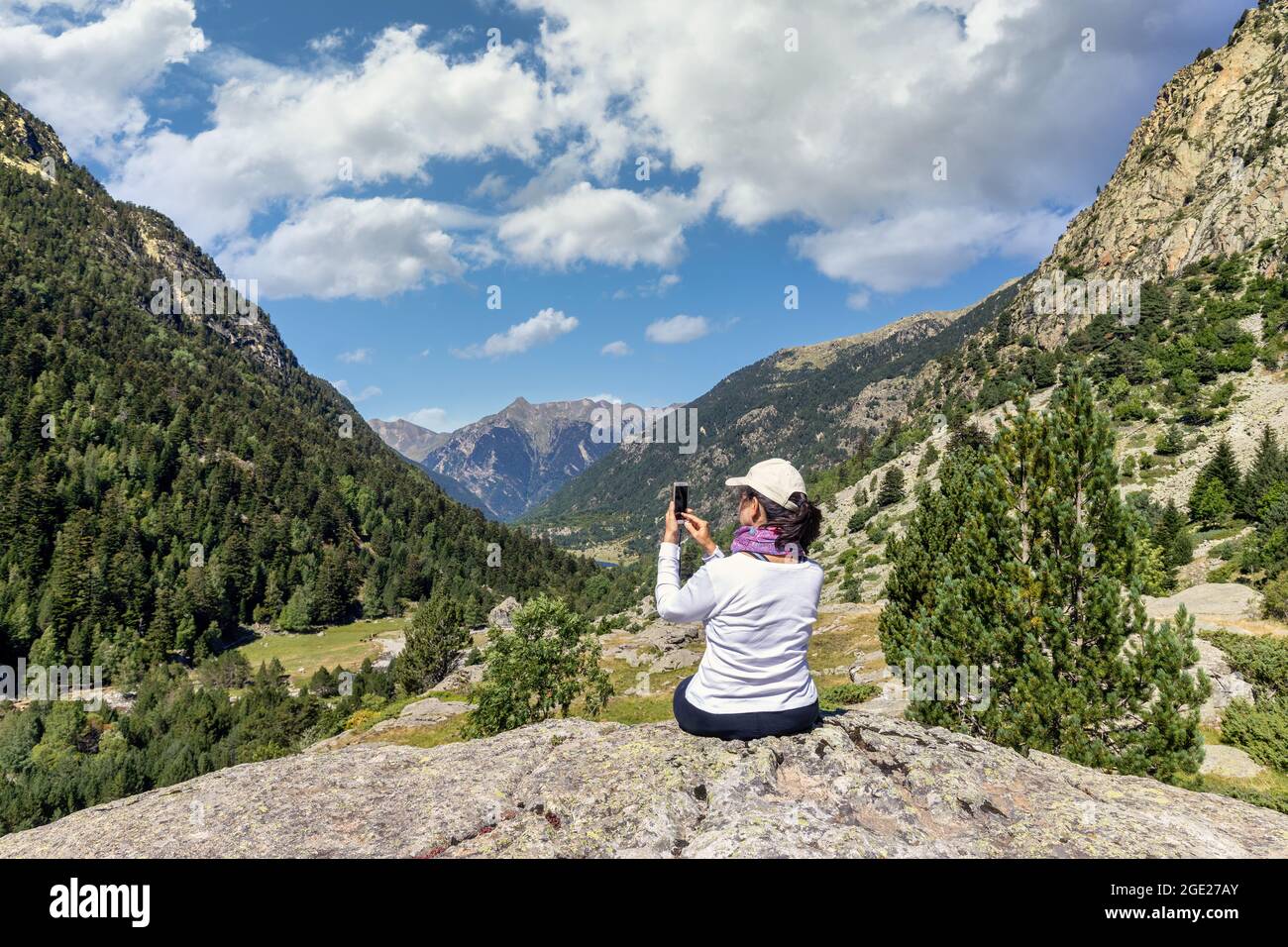 Eine Frau mittleren Alters fotografiert mit dem Handy vom spanischen Pyrenäenberg aus Stockfoto