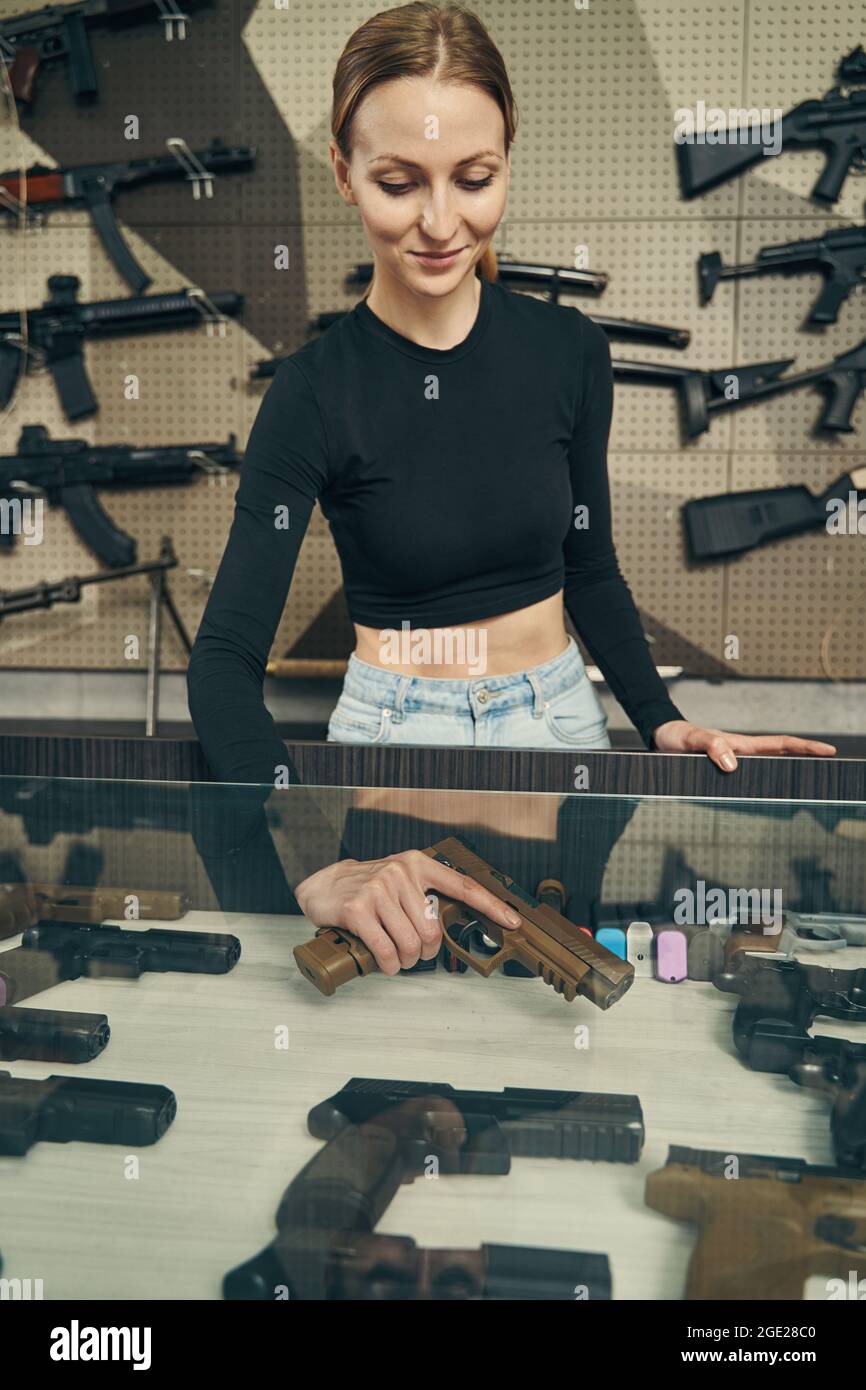 Erfahrener Waffenverkäufer, der eine Pistole für Kunden auswählt Stockfoto