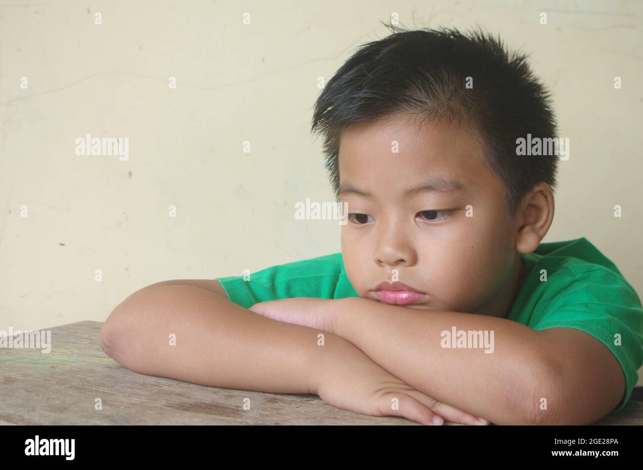 Einsamer Junge auf dem Tisch negative Kinder Emotion. Einsamkeit, Kind traurig Stockfoto