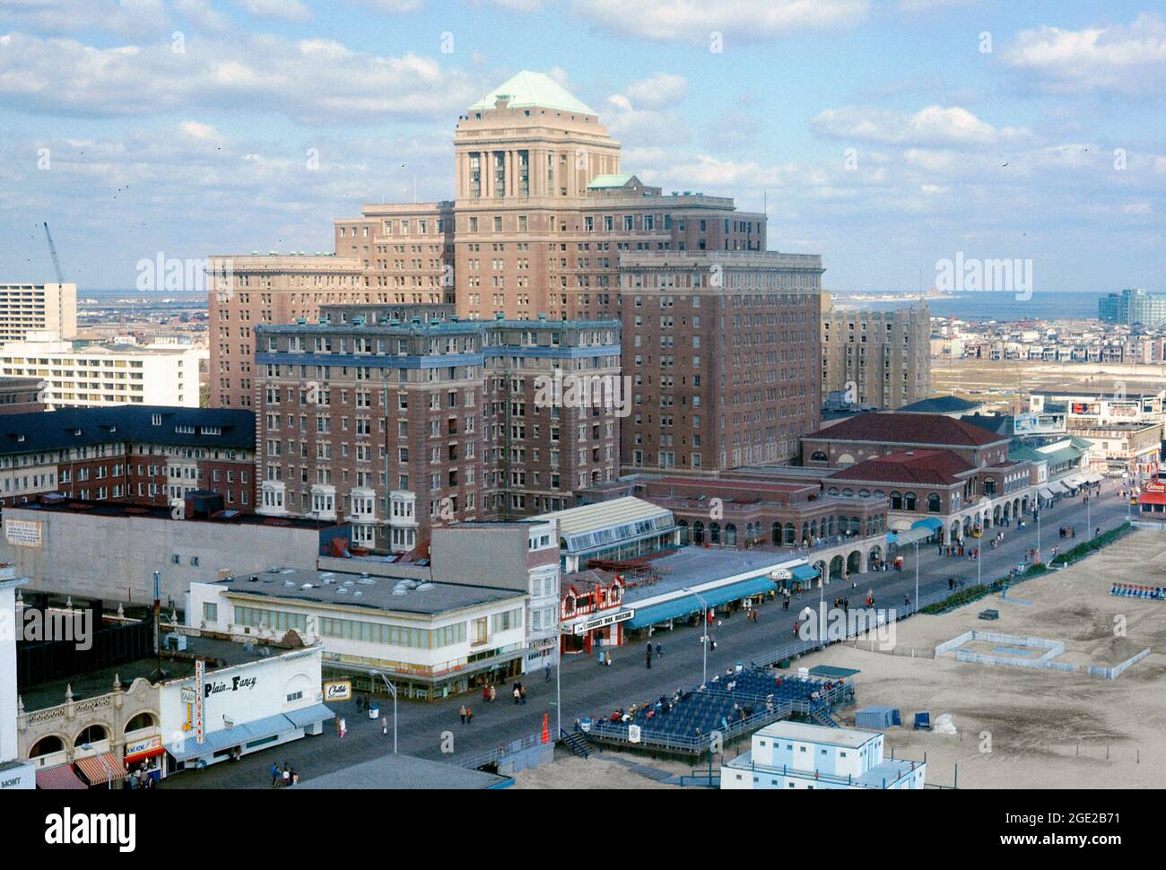 Atlantic City mit dem Hotelkomplex ‘Chalfonte-Haddon Hall’ hinter der berühmten Promenade und dem Strand in den 1960er Jahren. Die Resortstadt in New Jersey, USA, ist bekannt für ihre Hotels und Casinos. Die erste Promenade wurde 1870 gebaut, um Sand aus den Hotels zu halten. Das 1904 eröffnete Chalfonte House (Chalfonte Hotel) ist ein achtstöckiges Backsteingebäude. Die größere Haddon Hall wurde in den 1920er Jahren erbaut. Heute ist es das ‘Resorts’ Casino Hotel. 27 wurde ein 2004-stöckiger Rendezvous Tower hinzugefügt – die beiden früheren Gebäude waren weiß gestrichen – dieses Bild stammt aus einer amerikanischen Amateurfarbtransparenz der 60er Jahre. Stockfoto