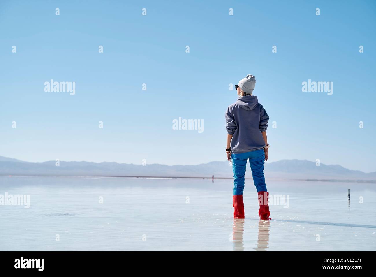 asiatische Frau, die im Wasser eines Salzsees steht und die Aussicht betrachtet Stockfoto