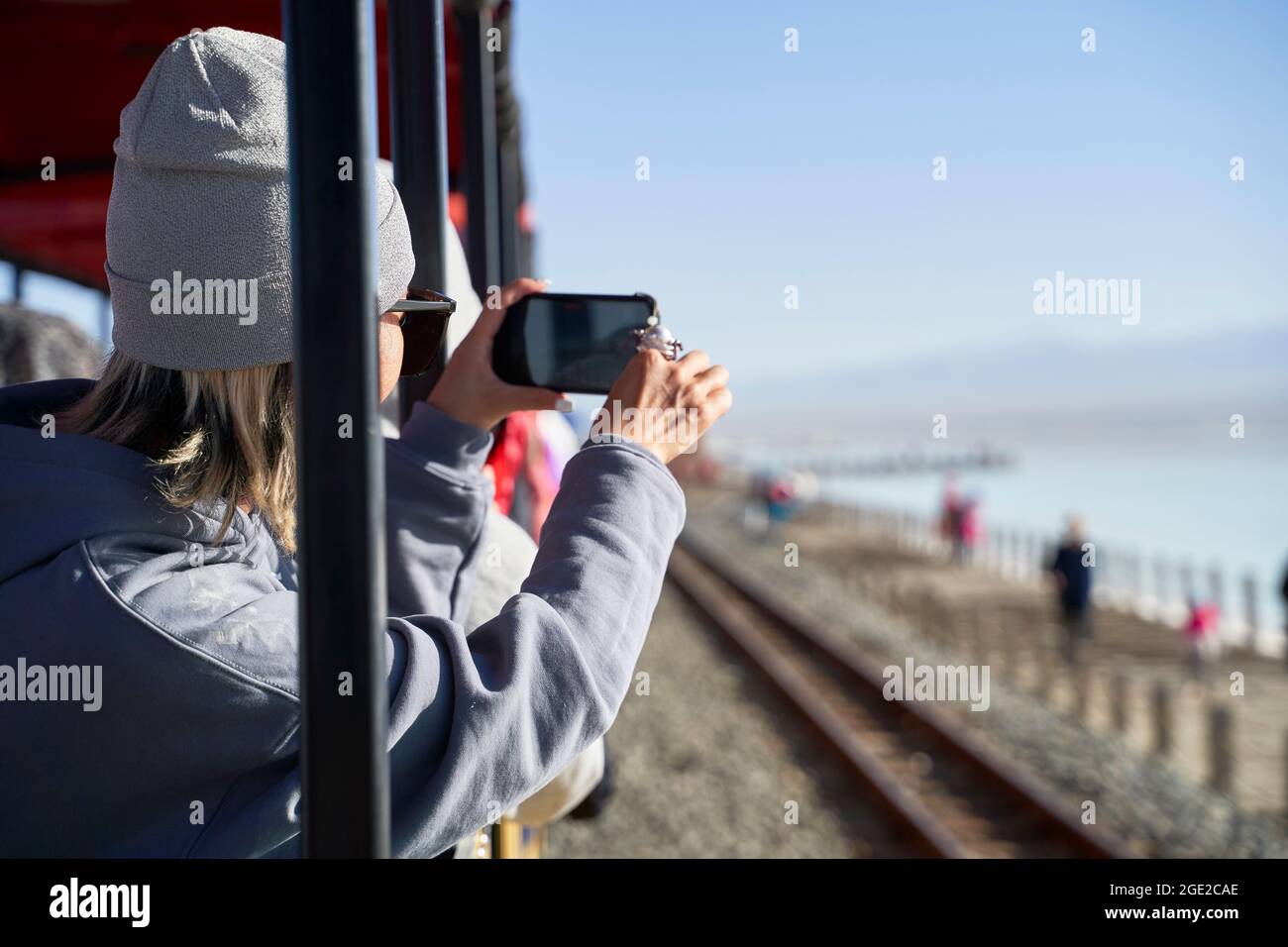 asiatische Frau, die ein Foto mit dem Handy in einem Sightseeing-Zug gemacht hat Stockfoto