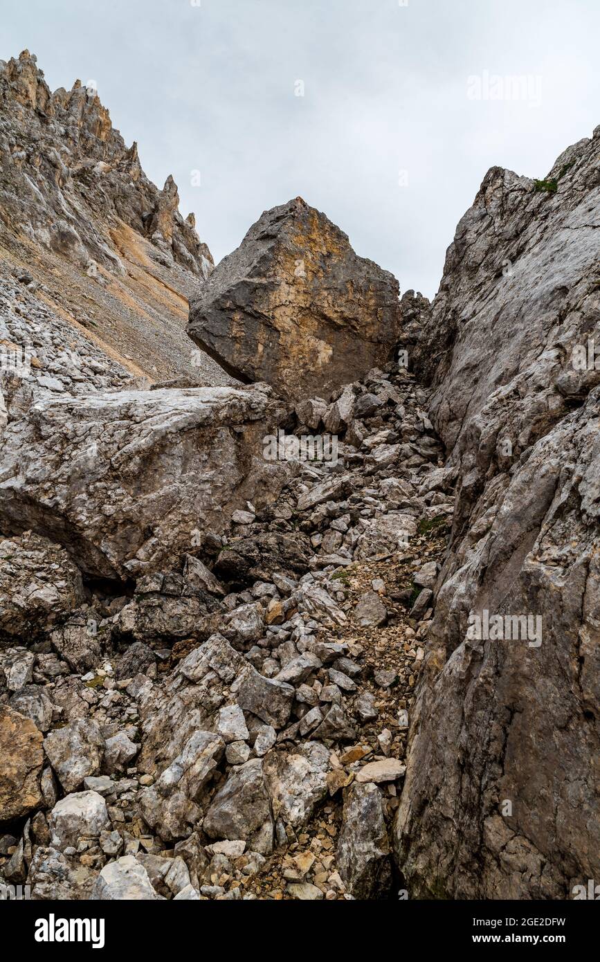 Bergkulisse mit großen Steinen, dolomitischen Gipfeln und bewölktem Himmel auf der Latemar-Berggruppe in den Dolomiten Stockfoto