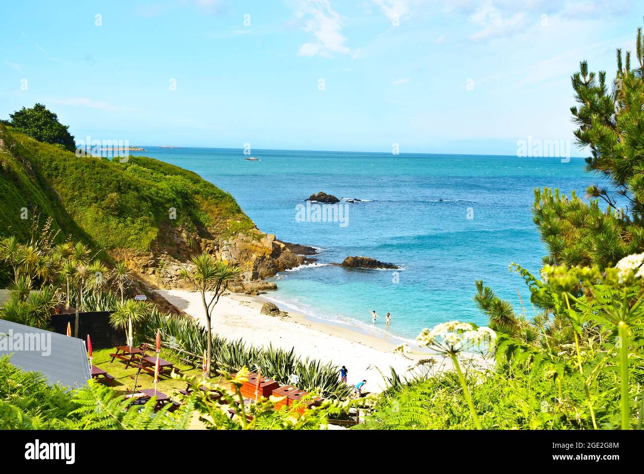 Herm, Kanalinseln, Großbritannien - 1. Juli 2016: Das Café und der wunderschöne Strand an der Belvoir Bay an einem ruhigen Sommernachmittag, nur wenige Menschen in der Nähe. Stockfoto