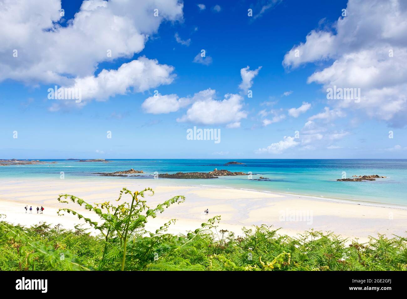 Herm, Kanalinseln, Großbritannien - 2. Juli 2016: Weißer Sand, Felsen und flaches türkisfarbenes Wasser am schönen und fast leeren Shell Beach im Sommer. Stockfoto