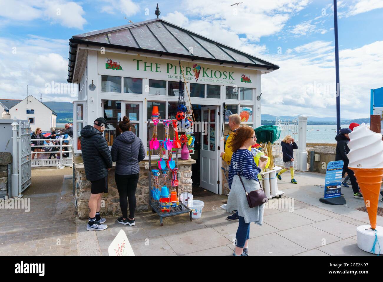 Besucher, die an einem Sommernachmittag am Beaumaris Pier in Anglesey North Wales Eis am Pier Kiosk kaufen Stockfoto