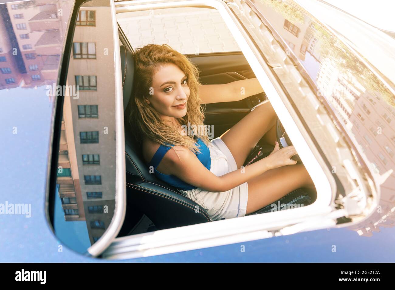Draufsicht vom Schiebedach einer jungen schönen Frau, die auf dem Autositz sitzt und vorsichtig fährt. Hochwertige Fotos Stockfoto