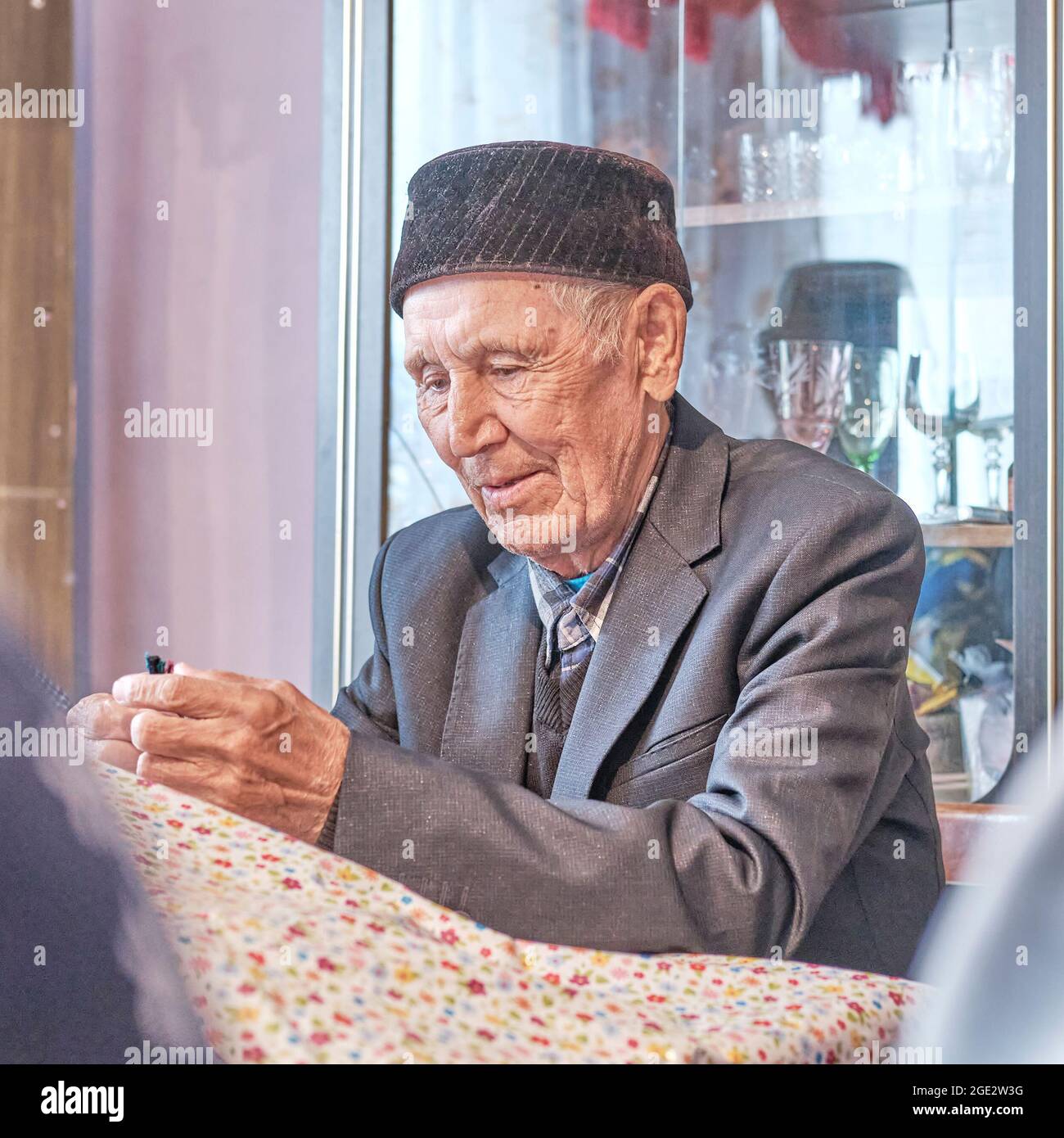 Verloren in Gedanken asiatischen älteren muslimischen Mann sitzt am Tisch zu Hause Stockfoto