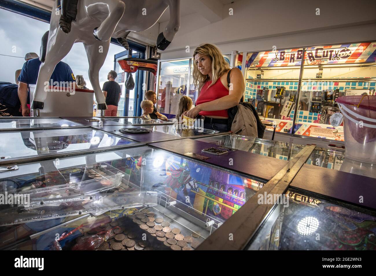 Menschen, die die Spielhallen genießen, spielen Spielautomaten in Goodrington Sands, Paignton Seaside Resort an der Küste von South Devon, Großbritannien Stockfoto